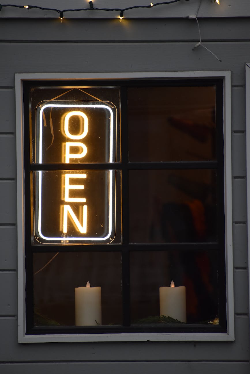 a neon sign and candles in a window