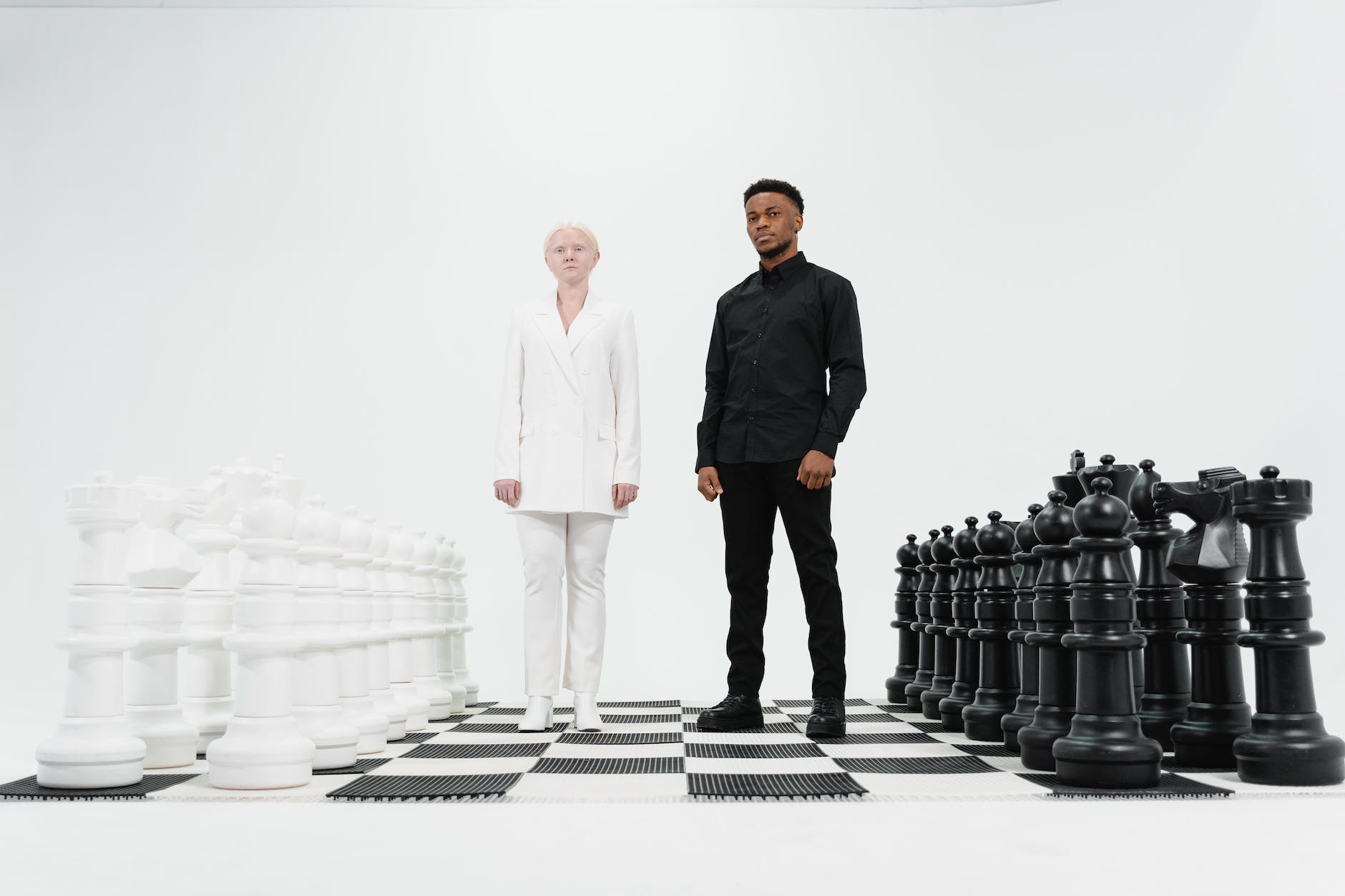 a man and a woman standing on a giant chess board